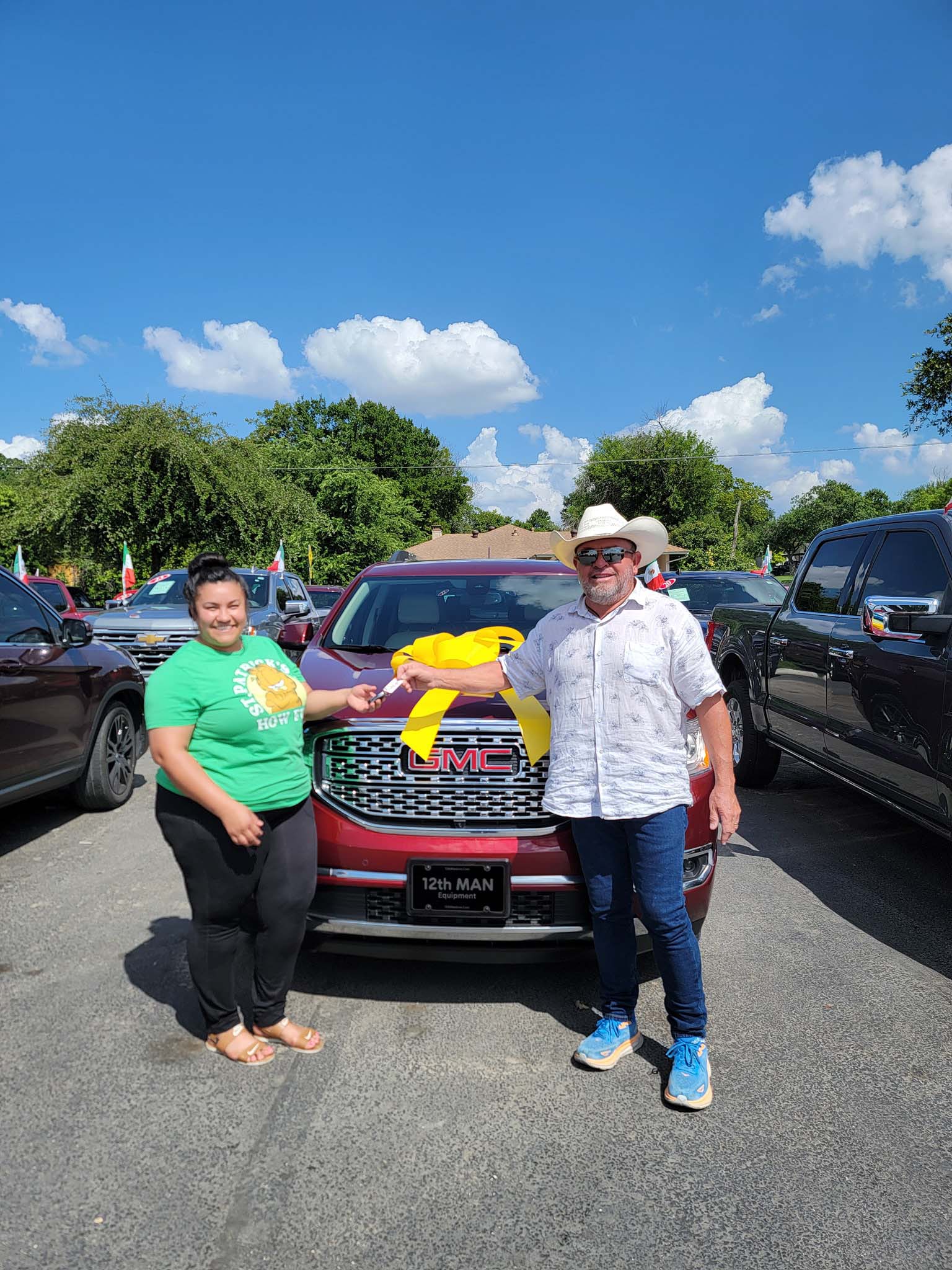 A happy customer receiving the keys to their vehicle at 12th Man Equipment